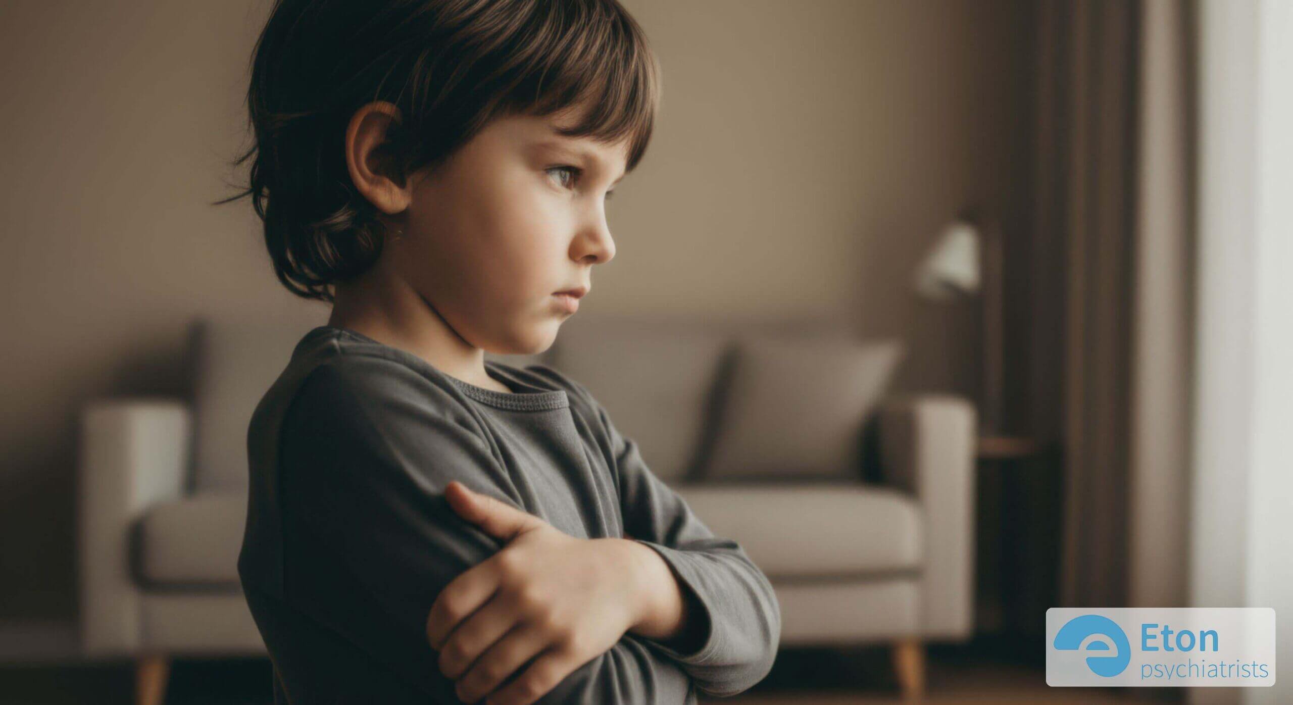 A child stubbornly crossing their arms and looking away, suggesting the persistent defiance characteristic of ODD.