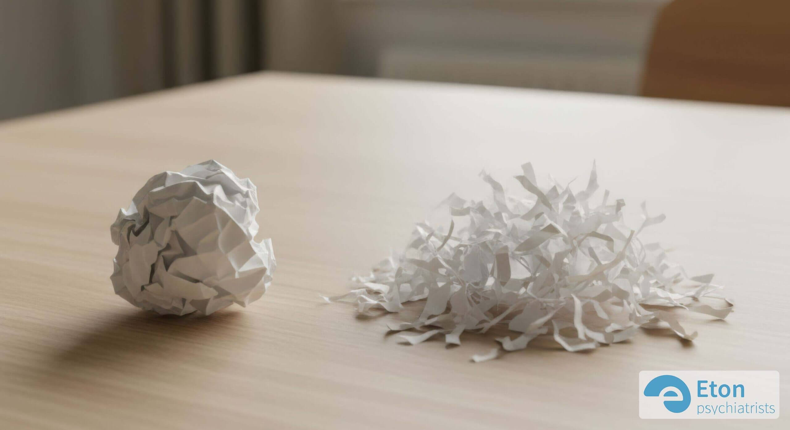A conceptual image showing a crumpled paper ball next to a pile of shredded paper, contrasting a tantrum's frustration with a meltdown's loss of control.