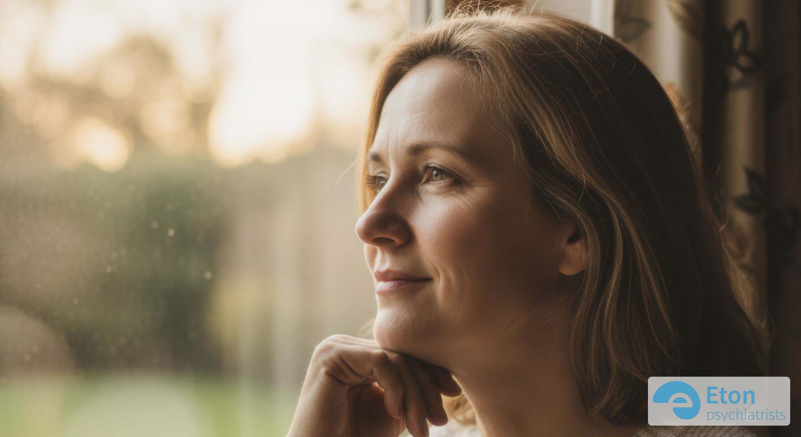 An adult curled up in an armchair in dim light, looking drained and withdrawn, depicting autistic burnout.