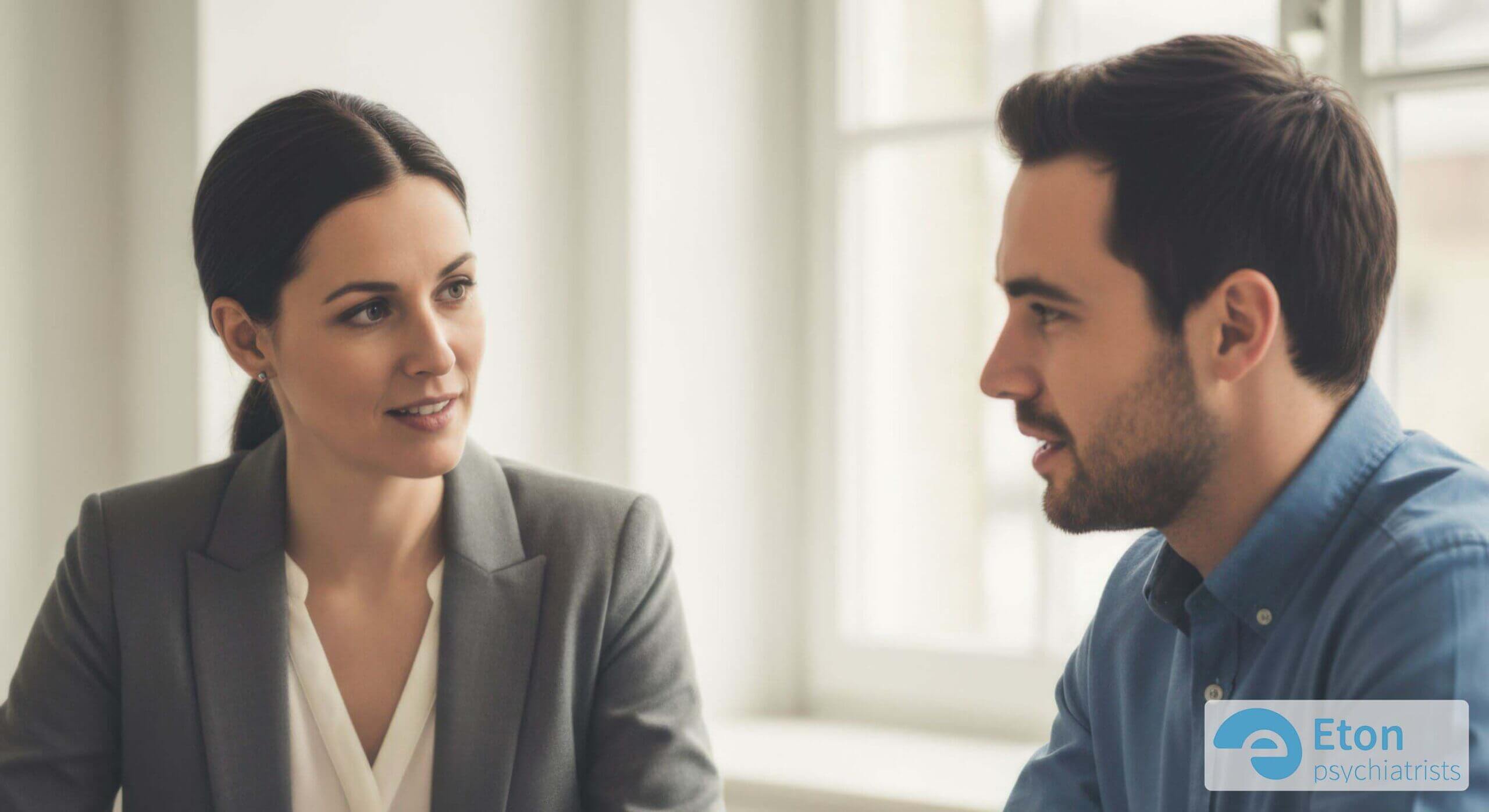 An Access to Work assessor and an employee having a supportive, collaborative conversation during a workplace needs assessment.