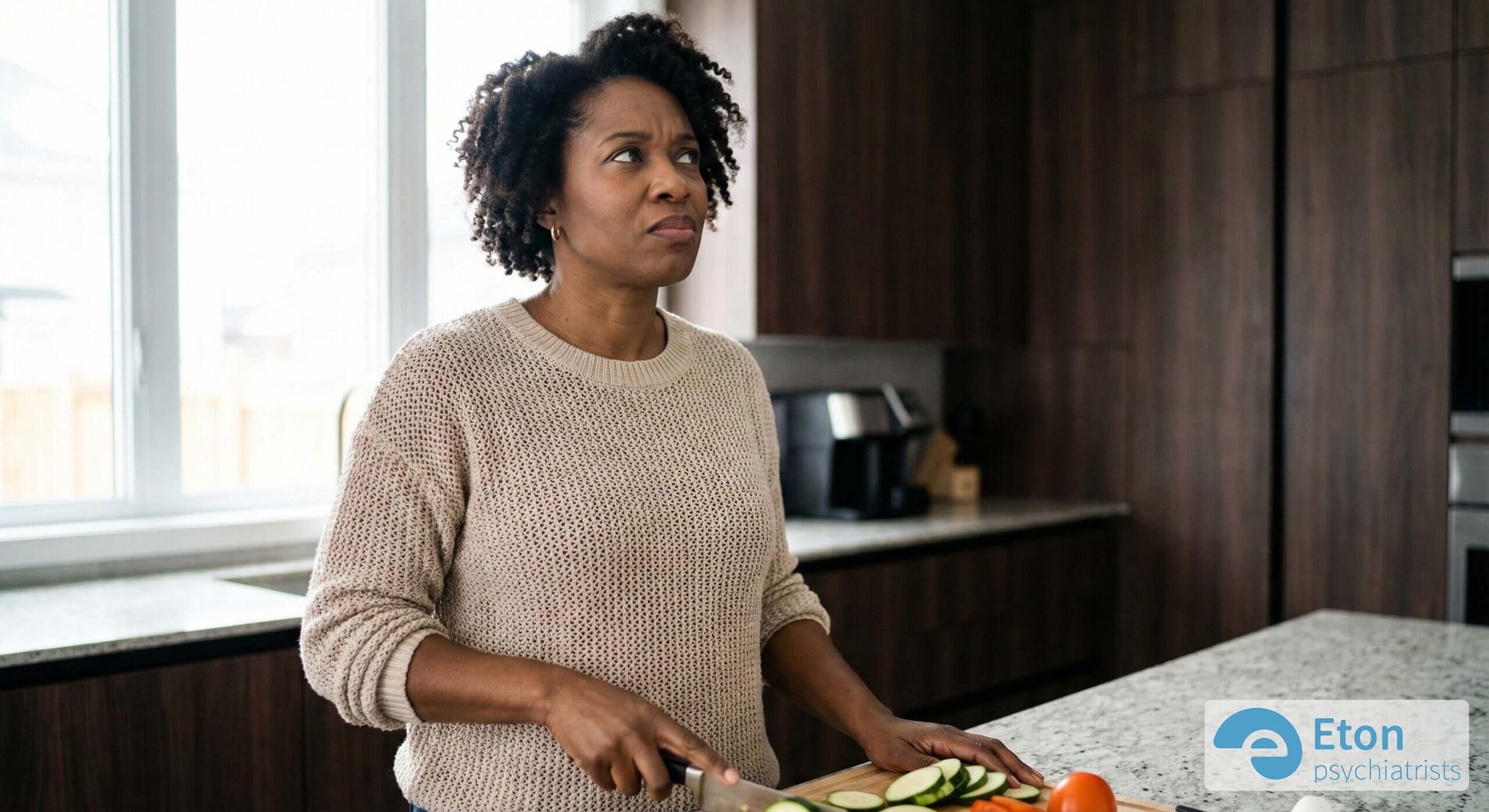 A woman cutting vegetables in a kitchen, representing nutritional lifestyle adjustments.